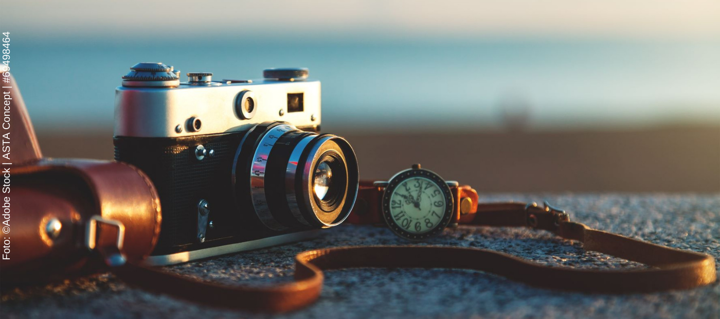 Eine Vintage Kamera mit Lederband und einer Lederarmbanduhr.